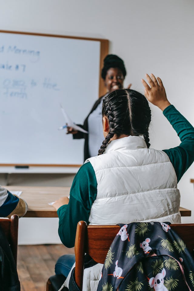 A little girl asking a question in class